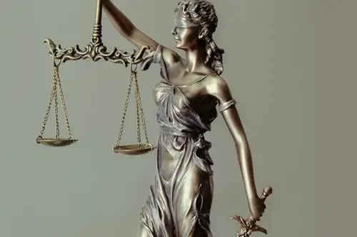 Image of Justice statue blind folded, holding scales and a sword.