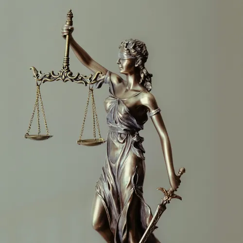 Image of Justice statue blind folded, holding scales and a sword.