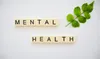 Mental Health spelled out in Scrabble tiles with a piece of greenery next to it.