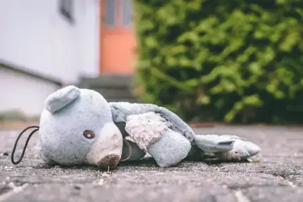 “Injured” teddy bear laying face down on the ground.