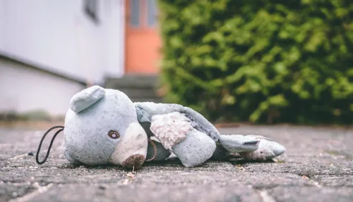 “Injured” teddy bear laying face down on the ground.